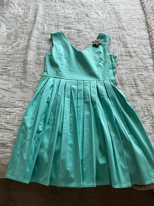 Cyan color dress with a brooch