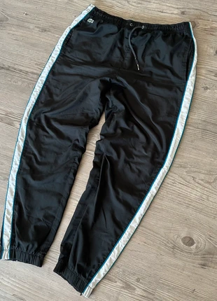 "Lacoste Sporthose mit seitlichem Streifen und Reißverschluss am Beinabschluss – Schwarz/Weiß/Blau", marque: Lacoste, état: Bon état, taille: L, 28,00 €, 30,10 € Protection acheteurs incluse