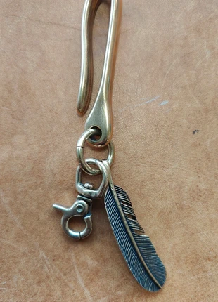 Brass Key-hook with feather (without key), merk: Wald leatherworks, staat: Nieuw zonder prijskaartje, maat: Universeel, € 30,00, € 32,20 inclusief Kopersbescherming